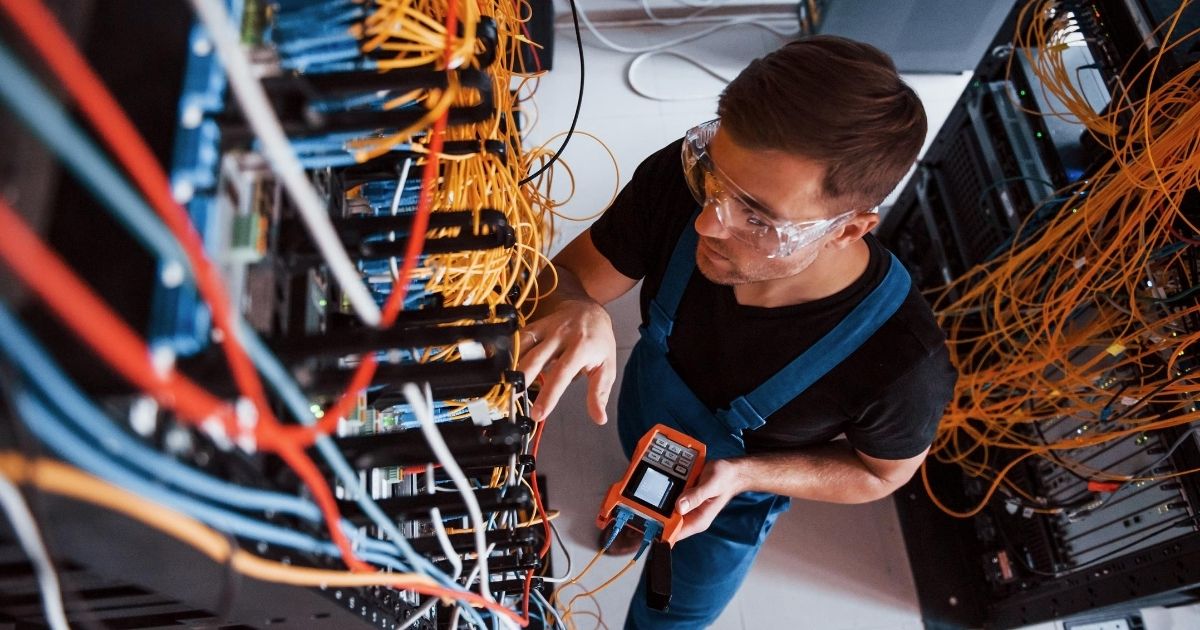 Επαγγελματίας ελέγχει με ειδικό όργανο την καλωδίωση.