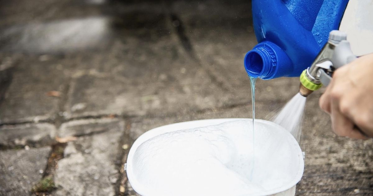Κάποιος ρίχνει υγρό καθαρισμού και νερό μέσα σε λεκάνη