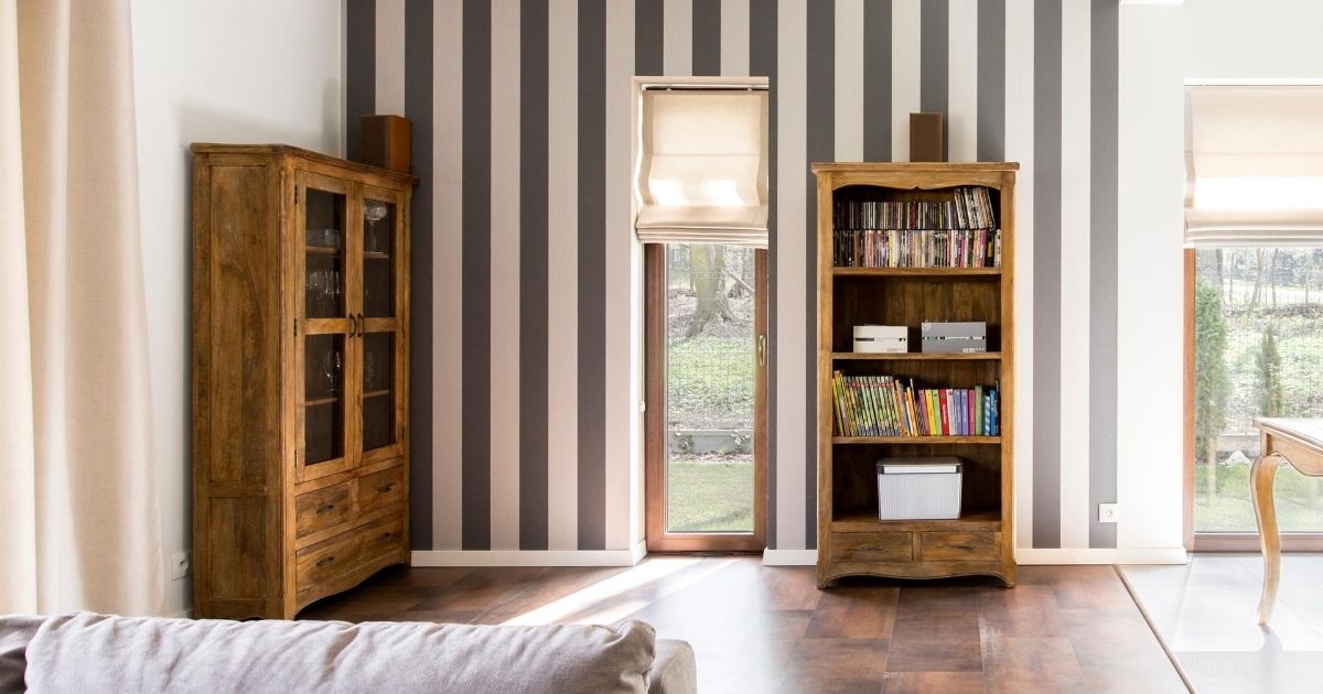 Ριγέ τοίχος με πόρτα κήπου ανάμεσα και δύο ξύλινες βιβλιοθήκες