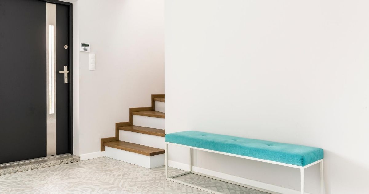 Μια είσοδος σπιτιού που διαθέτει πόρτα ασφαλείας. Δίπλα οι σκάλες που οδηγούν στον επάνω όροφο.