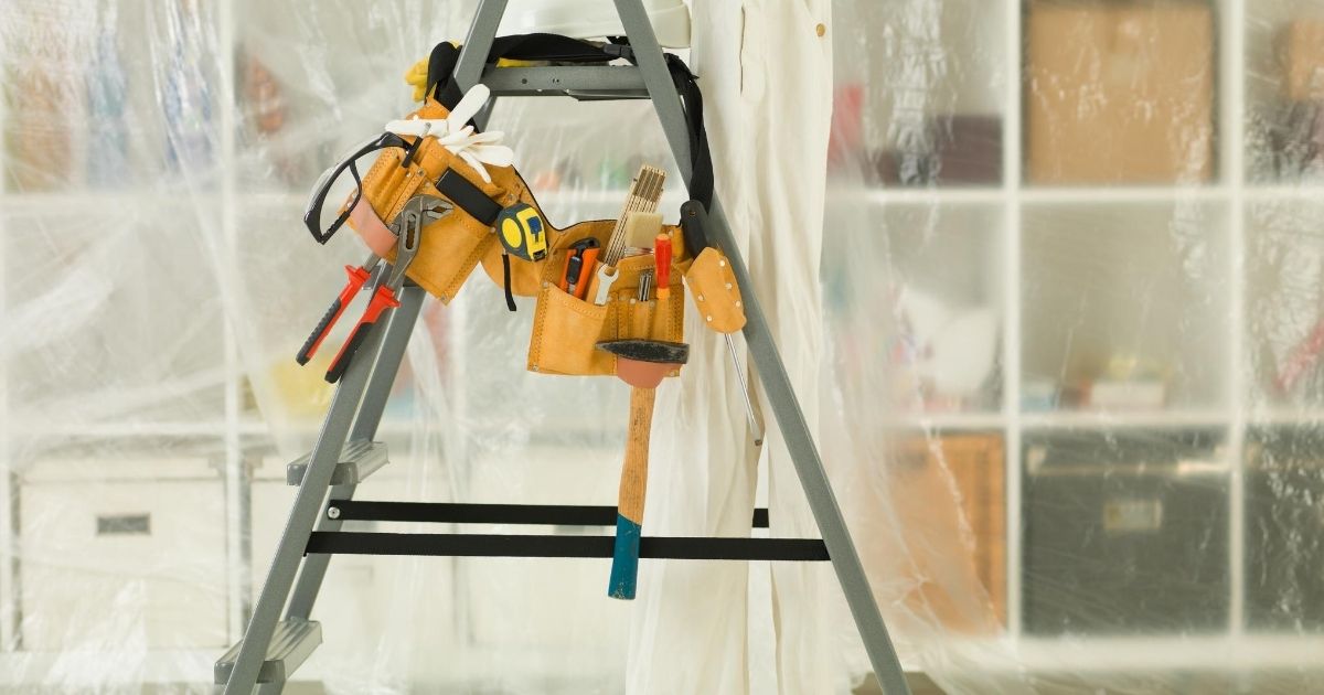 Μια σκάλα ανοιχτή που έχει επάνω της κρεμασμένες  επαγγελματικές θήκες με διάφορα εργαλεία.  