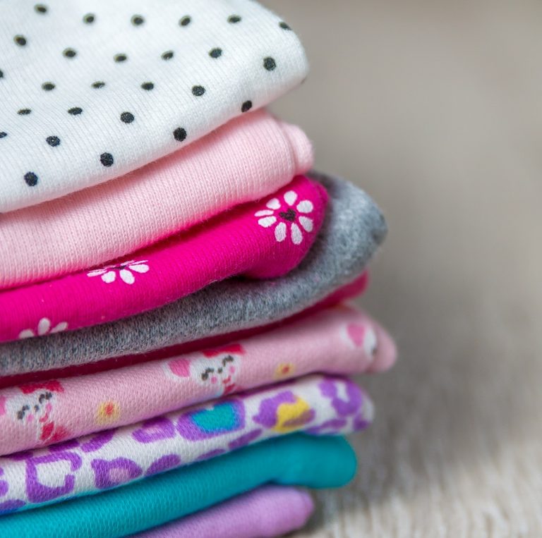 Στοίβα διπλωμένων ρούχων, σε διάφορα χρώματα.