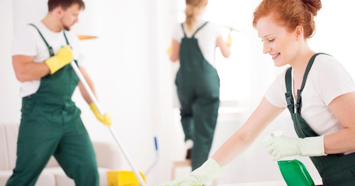 Συνεργείο καθαρισμού, δύο γυναίκες και ένας άνδρας, καθαρίζουν σπίτι.