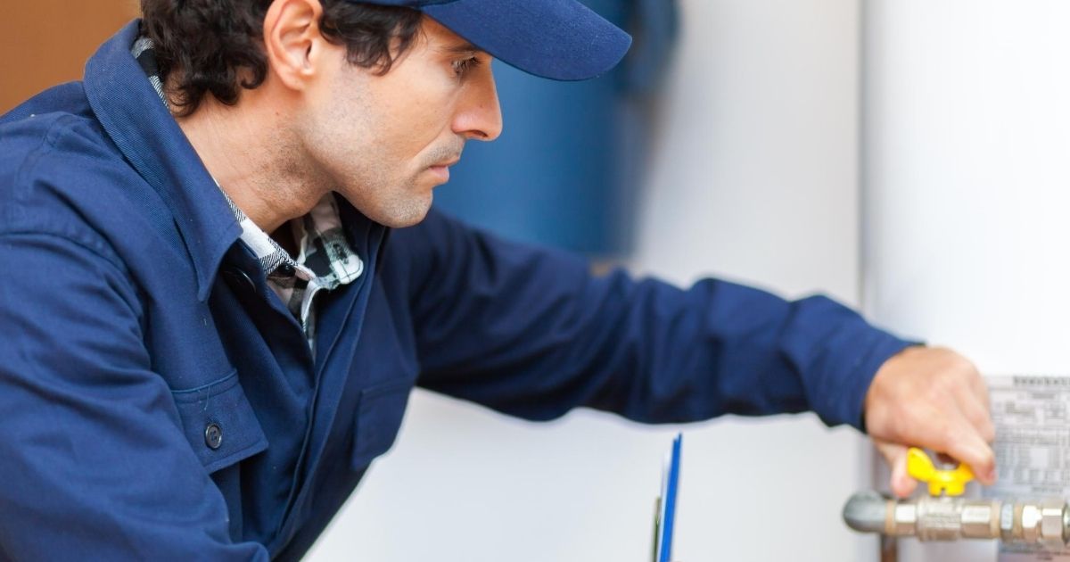 Ένας επαγγελματίας ρυθμίζει τον διακόπτη σε σωλήνα ηλιακού θερμοσίφωνα.