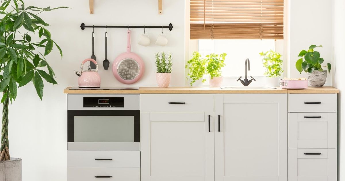 Πάγκος κουζίνας με νεροχύτη, εστίες μαγειρέματος και από κάτω ντουλάπια. Πίσω από τον νεροχύτη υπάρχει παράθυρο.